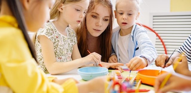 Kobieta pracuje z dziećmi w przedszkolu